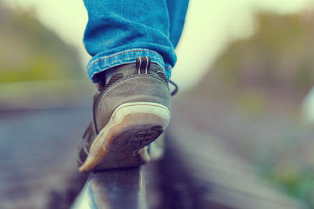 railroad rails feet sneakers jeansの写真素材
