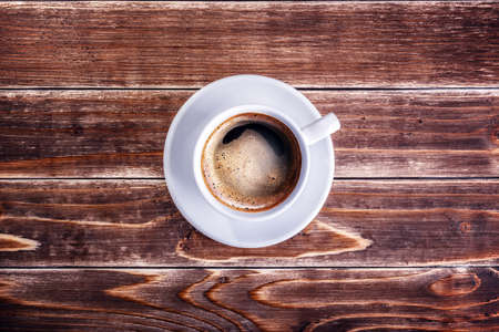 cup of coffee on the wooden table backgroundの写真素材