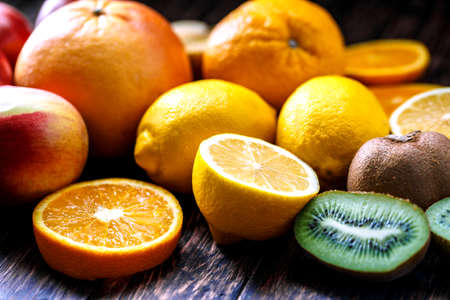 orange, lemon, fruit, kiwi, apple on a wooden boardの写真素材