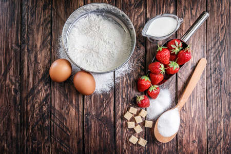 flour, egg strawberry on a wooden boardの写真素材