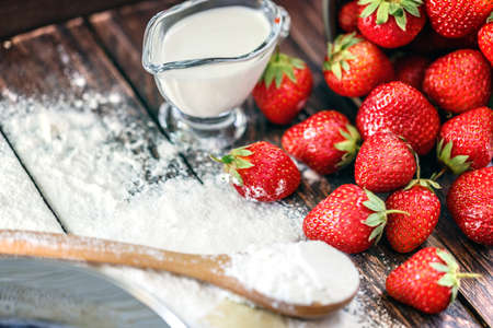 flour, egg strawberry on a wooden boardの写真素材