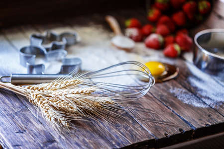 flour, egg strawberry on a wooden boardの写真素材