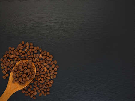 roasted coffee beans on a black slate blackboard