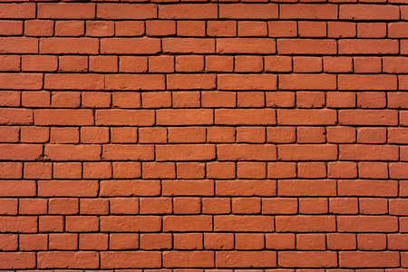 Red stone brickwork, background on a sunny day