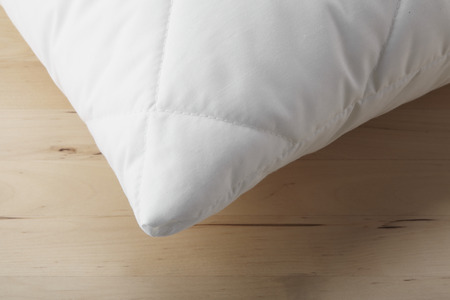 White pillow close-up on wooden background.の写真素材