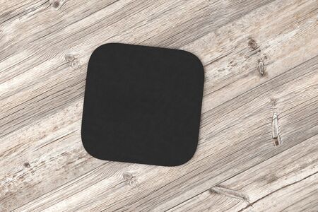 Square black coaster. Isolated on wood background. 3d renderの写真素材