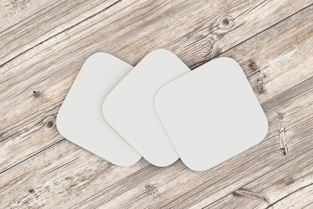 White square coasters. Isolated on wood background. 3d renderの写真素材