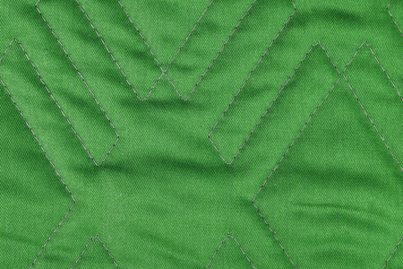 Green quilted fabric texture with geometric patternの写真素材