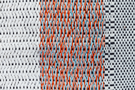 Colorful (orange and white stripes) hand weaving matting tweed fabric texture. Closeup horizontal fragmentの写真素材