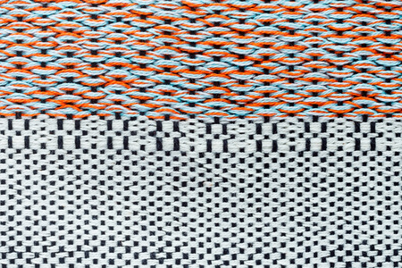 Colorful (orange and white stripes) hand weaving matting tweed fabric texture. Closeup horizontal...