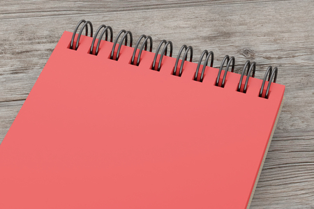 Red spiral notepad isolated on wooden background. Include clipping path of the border of notepad. 3d renderの写真素材
