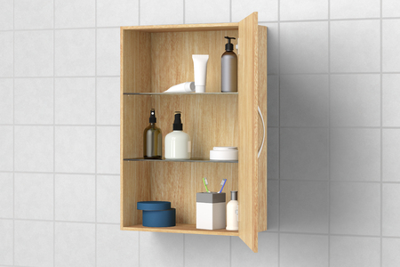 Open wooden bathroom cabinet with cosmetics and bath products isolated on white tiled wall with clipping path. 3d illustrationの写真素材