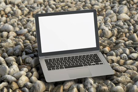 Blank screen laptop on gravel. Isolated with clipping path around gadget. 3d illustrationの写真素材