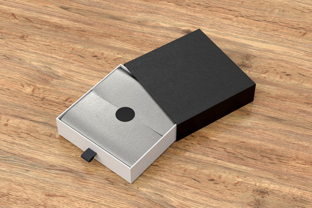 Opened black drawer sliding box with gift wrap foil on wooden background. Include clipping path...