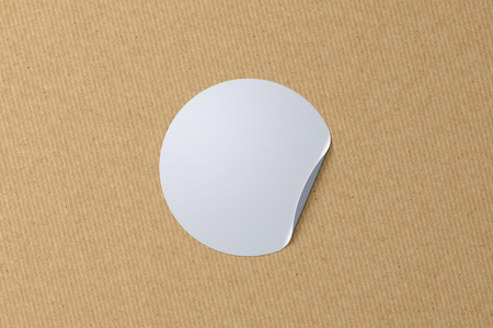 Blank white sticker with bent edge on cardboard background. 3d illustrationの写真素材