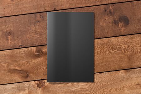 Black brochure or booklet cover mock up on wooden background. Isolated with clipping path around brochure. View above. 3d illustratuionの写真素材