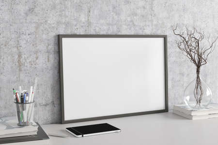 Horizontal poster frame mockup on the white table of home studio workspace with concrete wall. Side...