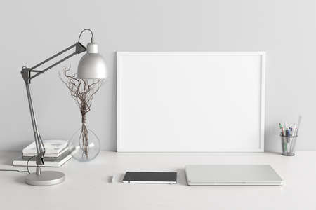 Horizontal poster frame mockup on the white table of home studio workspace with white wall. Front view, clipping path around poster picture. 3d illustrationの写真素材