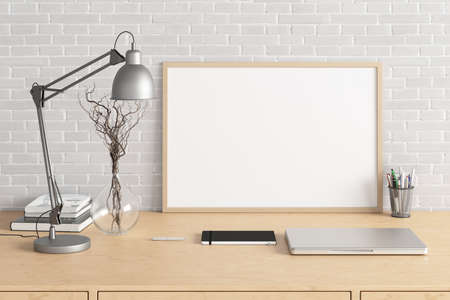 Horizontal poster frame mockup on the wooden table of home studio workspace with white brick wall....