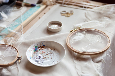 Workplace of an embroiderer with embroidery frames, angel embroidery, beads