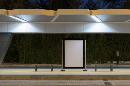 Poster stand at night. Street billboard mock up at a public transport stop.