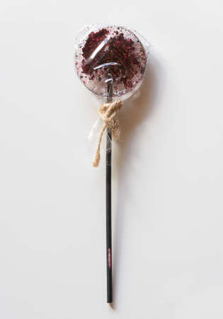 Lollipop on a stick in a transparent wrapper on a white background.の写真素材