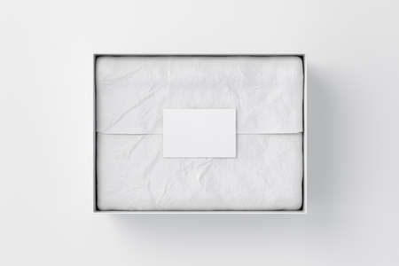 Gift box mock up. White gift box with blank label or business card on wrapping paper. White background. Directly above view. 3d renderの写真素材