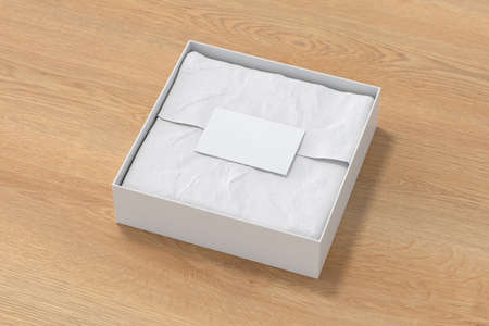 Square gift box mock up. White gift box with blank label or business card on wrapping paper. Wooden background. Side view. 3d illustrationの写真素材
