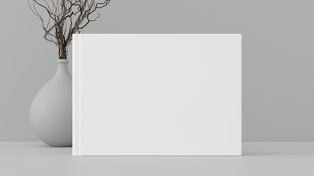Horizontal book cover mock up standing on a white desk with white wall background. 3d illustrationの写真素材