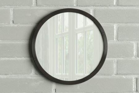 Dark wooden round frame poster mock up on the  white brick wall. Front view. 3d illustrationの写真素材