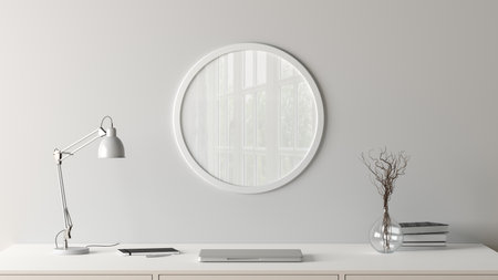 White round poster frame mock up on the white wall of home studio workspace. Front view. 3d illustrationの写真素材