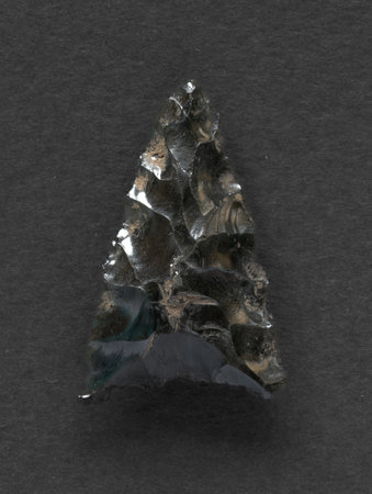 Neolithic obsidian arrowhead on dark backgroundの写真素材
