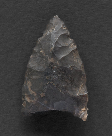 Neolithic flint arrowhead on white backgroundの写真素材