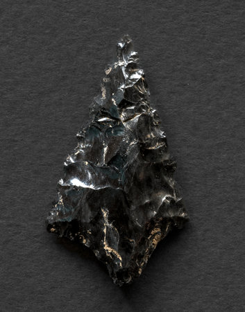 Neolithic obsidian arrowhead on dark backgroundの写真素材