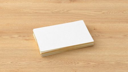 Business card with gold trim mockup. Stack of business cards on wooden background. Side view. 3d illustrationの写真素材