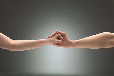 A gesture of restraint. A man's palm wrapped around a woman's fistの写真素材