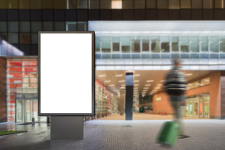 Blank advertising stand at night against contemporary office building and shopping mall. 3d renderの写真素材