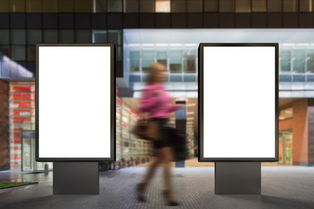 Two blank advertising stand at night against contemporary office building  and shopping mall. 3d renderの写真素材
