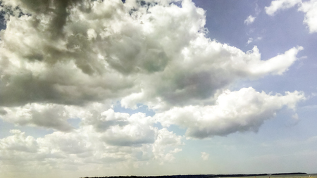 cumulus clouds like fluffy, white cotton balls on the blue sky. Beautiful in sunset, varying sizes and shapesの写真素材