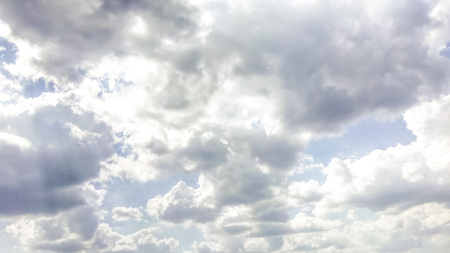 cumulus clouds like fluffy, white cotton balls on the blue sky. Beautiful in sunset, varying sizes and shapesの写真素材
