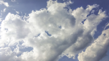 cumulus clouds like fluffy, white cotton balls on the blue sky. Beautiful in sunset, varying sizes and shapesの写真素材
