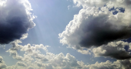 cumulus clouds like fluffy, white cotton balls on the blue sky. Beautiful in sunset, varying sizes and shapesの写真素材