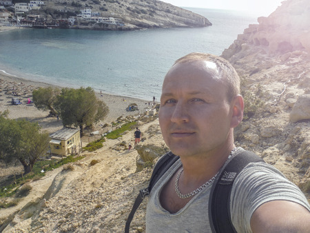 Tourist taking selfie at Matala beach, Crete, Greece. Hiker.の写真素材