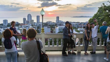 PATTAYA, THAILAND - NOVEMBER 21, 2017:  Aasian tourists and Panoramic view  from observation deck. long tower, different buildings and ocean in the background. Big Buddha Hill Sunset.のeditorial素材