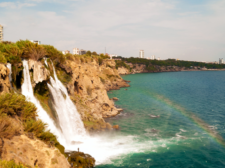 View of the Lower waterfall and rainbow Upper Illuninated Duden in the city of Antalya. view of water cascading from platform into Mediterranean sea. Summer vacation concept. Copy space. Toned pictureの写真素材