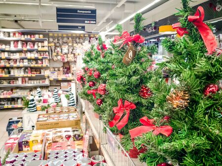 TALLINN, ESTONIA - 09 NOVEMBER 2018: Christmas ornaments shop MAXIMA. Toys , Beautiful green trees with red bows. shelves and many goods. concept of new year decoration ideas.のeditorial素材