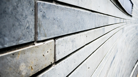 Gray Wall of Modern house With Diminishing Perspective. Curved walls. Slate stone wall surface,...