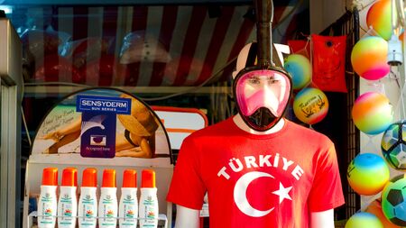 KONAKLI, ALANYA, TURKEY - 06 JULY 2018: The market on the street. Mannequin with underwater mask and red t-shirt. Suntan cream. Goods for touristsのeditorial素材