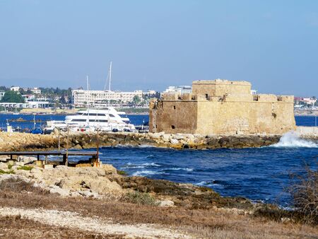 Modern royal with green paphos on blue background. Famous travel destination. Nature landscape. Tourist attraction. Stone wall, fort to protect the harbourの写真素材
