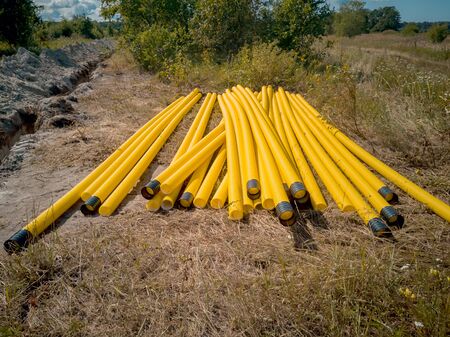New pipeline of propylene on a background of green forest. Construction site of an overland pipeline. A long trench, dug out to drain the land and laying of pipes for communicationの写真素材